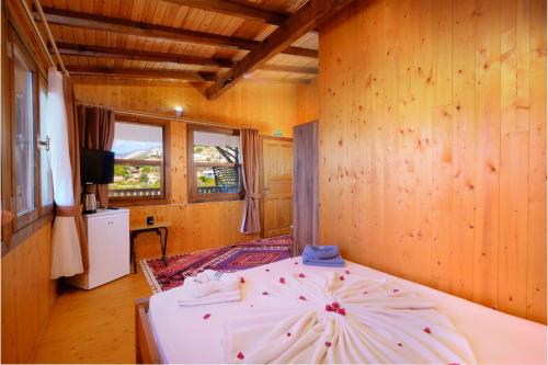 a bedroom with a bed in a room with wooden walls at BlueSea Faralya-Sardalya Full Deniz Manzaralı in Kızılcakaya