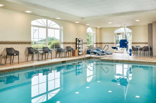 a large swimming pool with chairs and tables at Hampton Inn & Suites Hershey Near the Park in Hummelstown