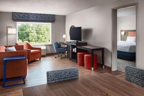 a hotel room with a bed and a desk with a television at Hampton Inn & Suites Hershey Near the Park in Hummelstown