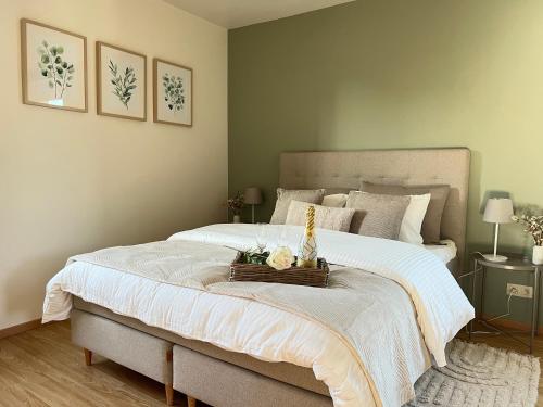 a bedroom with a large bed with a basket of flowers on it at Isa'Bellescale - Fully equipped house 2km from Brussels South Airport in Ransart