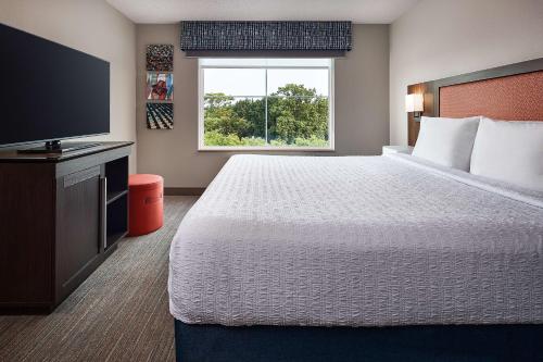 a hotel room with a bed and a flat screen tv at Hampton Inn & Suites Hershey Near the Park in Hummelstown