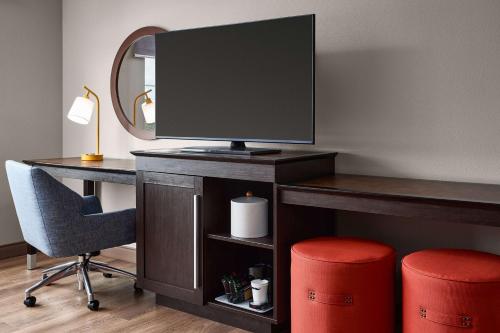 a desk with a television and a chair and a mirror at Hampton Inn & Suites Hershey Near the Park in Hummelstown