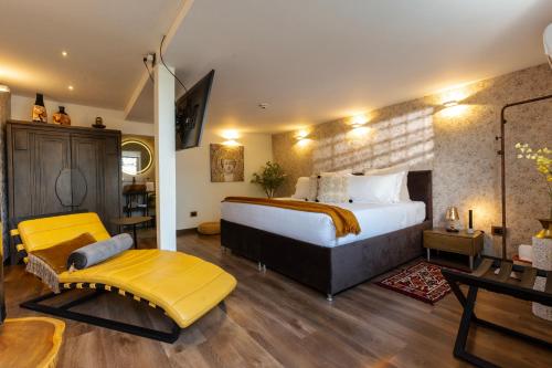 a hotel room with a large bed and a yellow bench at GreenOriental Resort in La Vega