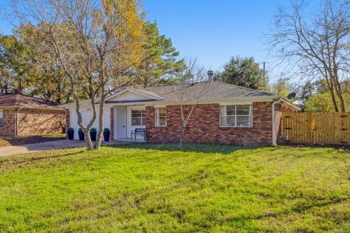 a brick house with a fence in a yard at Farmhouse Retreat in Bryan