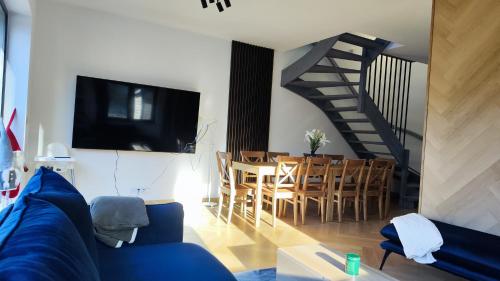 ein Wohnzimmer mit einem blauen Sofa und einem Esszimmer in der Unterkunft Stodoła pod Bacówką Zawoja Sauna Jacuzzi in Skawica