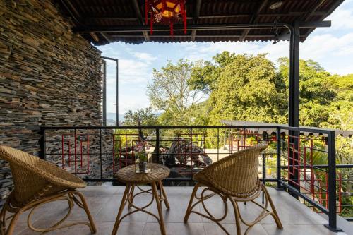 a patio with two chairs and a table on a balcony at GreenOriental Resort in La Vega