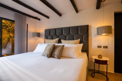 a bedroom with a large white bed with pillows at GreenOriental Resort in La Vega