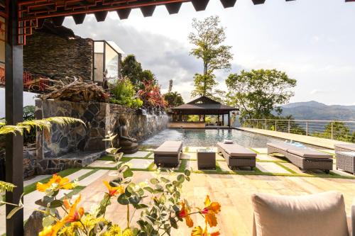a pool with lounge chairs and a gazebo at GreenOriental Resort in La Vega