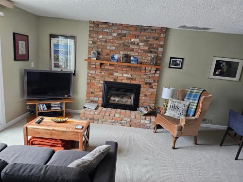 a living room with a fireplace and a tv at Window Hill in St. Albert