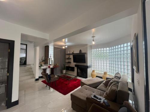 ein Wohnzimmer mit Couch und Kamin in der Unterkunft Casa Praia Brava Florianópolis. in Florianópolis