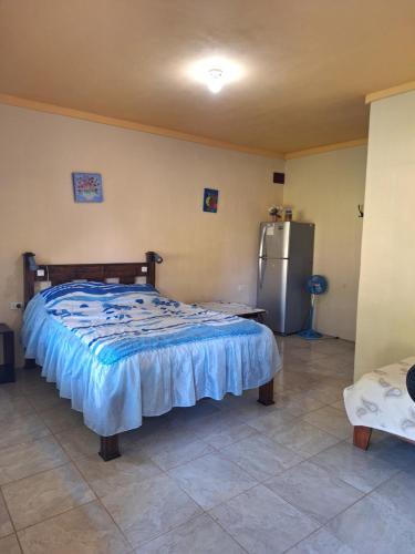 a bedroom with a bed and a refrigerator at La-Tica in Horquetas