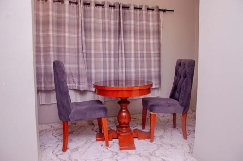 a table and two chairs and a wooden table and chairs at Lovely 3 bedroom Villa in Ikorodu