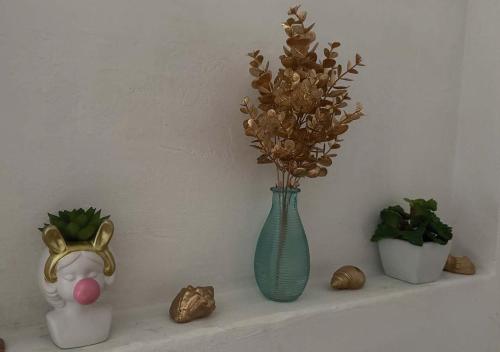 un estante con un jarrón con flores y otras decoraciones en Casa para 4 personas con parrillero, en Piriápolis