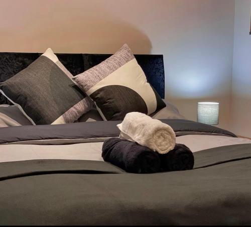 a bed with a bunch of pillows on it at Chic Central, Relaxing, Restful, Retreat, Heated Floors, High Ceiling, Open Plan, City Centre, 1BR in Sheffield