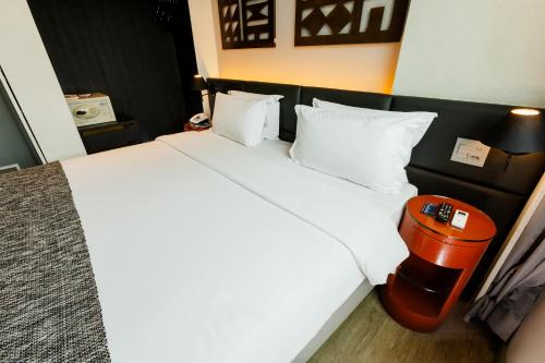 a bedroom with a large white bed with white pillows at Royal Golden Hotel - Savassi in Belo Horizonte