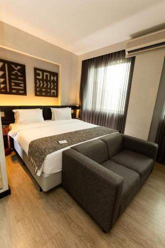 a bedroom with a large bed and a couch at Royal Golden Hotel - Savassi in Belo Horizonte