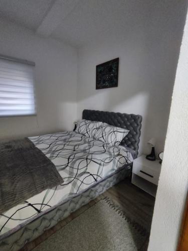 a bedroom with a bed and a window at Apartmani Valterova in Prijepolje