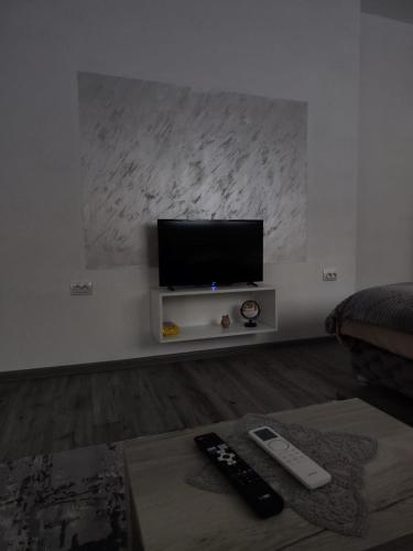 a living room with a tv and two remote controls at Apartmani Valterova in Prijepolje