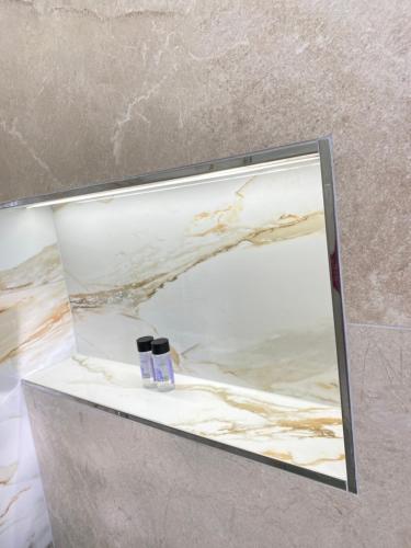 a mirror on a wall in a bathroom at Hotel Mesun Himare in Himare
