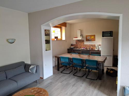 een woonkamer met een bank en een tafel met blauwe stoelen bij Helle Wohnung bei Willingen mit Terrasse in Willingen