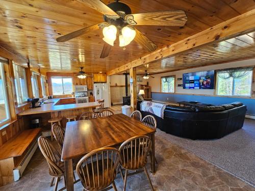 a dining room with a ceiling fan and a table at River Retreat with Hot Tub in Bethel