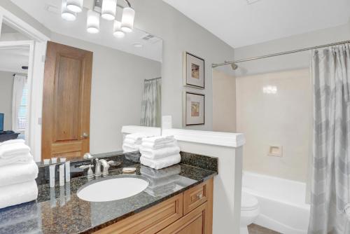 a bathroom with a sink and a toilet and a mirror at Florencia 505 in Pensacola