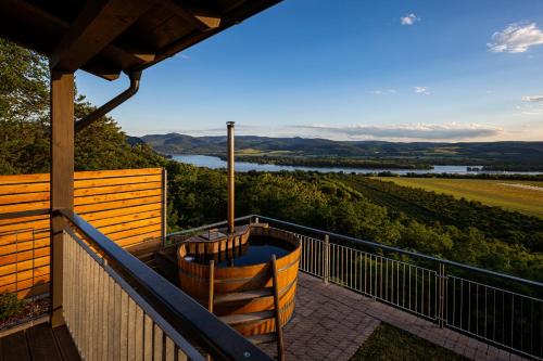 a balcony with a hot tub and a view at Fülemüle Vendégház in Zebegény