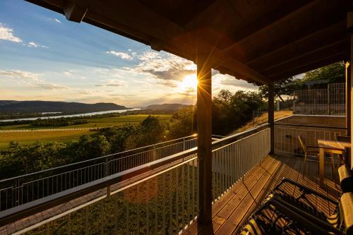a view from the balcony of a house with the sun setting at Fülemüle Vendégház in Zebegény
