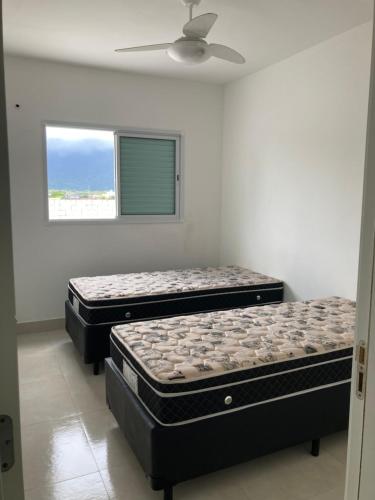two mattresses sitting in a room with a window at Apartamento praia grande frente do mar in Praia Grande