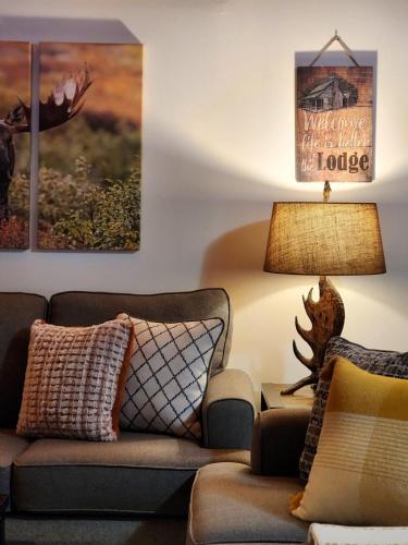 a living room with a couch and a lamp at Stylish Forest Lodge with Large Hot Tub, Firepit and Fireplace minutes to Gore Mountain in North Creek