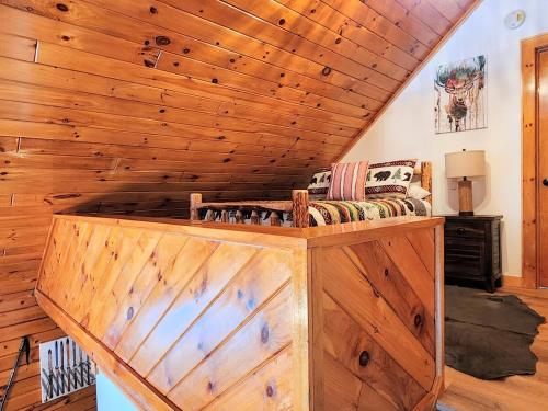 a living room with a wooden ceiling and a couch at Stylish Forest Lodge with Large Hot Tub, Firepit and Fireplace minutes to Gore Mountain in North Creek