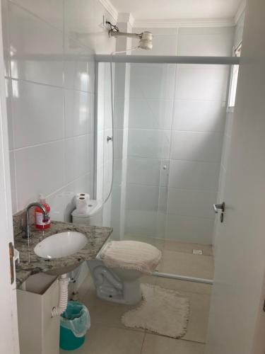 a white bathroom with a sink and a shower at Apartamento praia grande frente do mar in Praia Grande