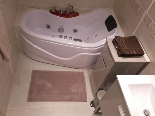 a white bath tub in a bathroom with a sink at Les Granges in Villars