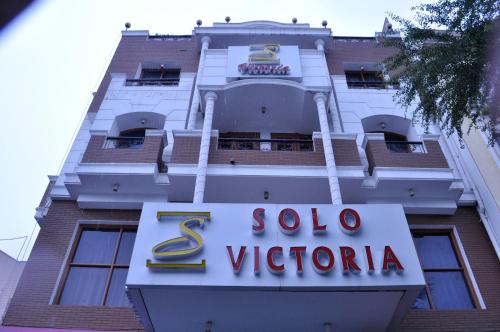 um edifício com um sinal em frente em Solo Victoria Hotel em Nova Deli