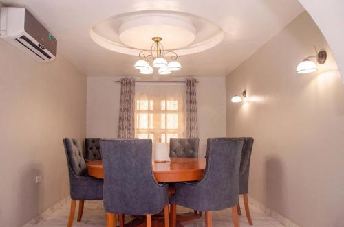 a dining room with a table and blue chairs at Lovely 3 bedroom Villa in Ikorodu