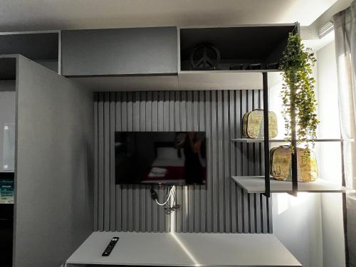 a kitchen with a sink and a tv on a wall at Get One - Bessa in Tambaú