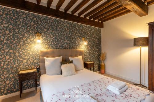 - une chambre avec un lit et un mur recouvert de papier peint dans l'établissement Le refuge Balte 4 - Nordic Spa with Wood Fire - Unique Experience, à Gonneville-sur-Honfleur