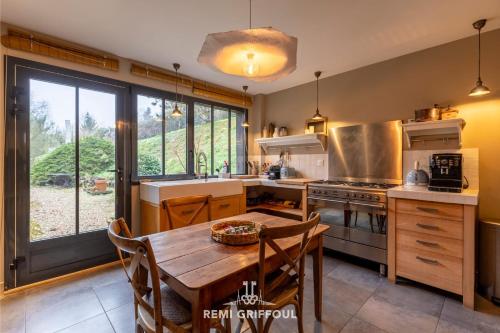une cuisine avec une table en bois et une grande fenêtre dans l'établissement Le refuge Balte 4 - Nordic Spa with Wood Fire - Unique Experience, à Gonneville-sur-Honfleur