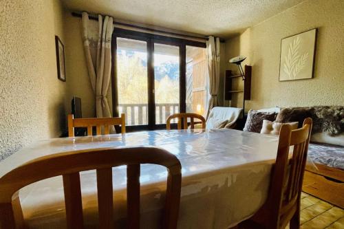 une chambre avec une table et des chaises ainsi qu'un salon dans l'établissement Charmant logement familial à La Salle-les-Alpes, à La Salle Les Alpes