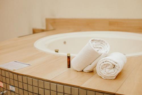 a bathroom with a bath tub with towels on a counter at Royal Golden Hotel - Savassi in Belo Horizonte