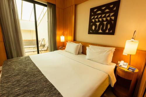 a hotel room with a large bed and a window at Royal Golden Hotel - Savassi in Belo Horizonte