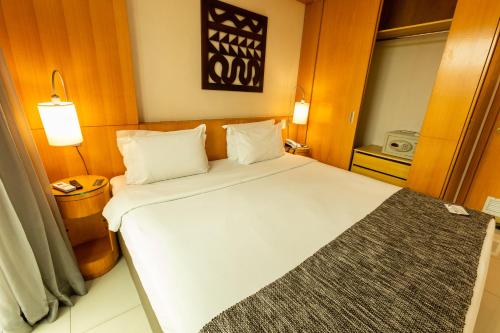 a bedroom with a large white bed in a room at Royal Golden Hotel - Savassi in Belo Horizonte