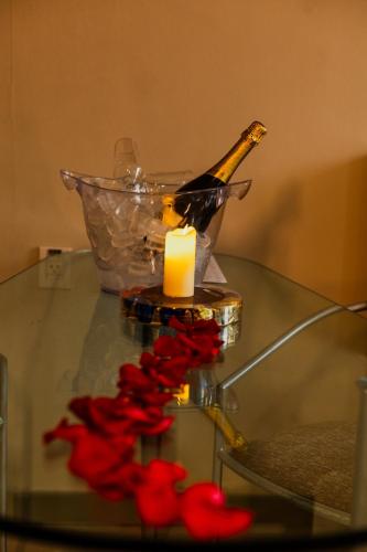 a bottle of champagne and a candle on a glass table at Royal Golden Hotel - Savassi in Belo Horizonte