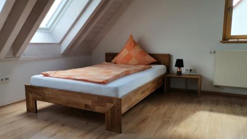 a bedroom with a wooden bed in a attic at Moderne und ruhige Ferienwohnung in Feuchtwangen