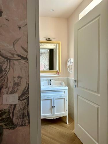a bathroom with a sink and a mirror at Villa Oteri Rooms & Bistrot in Bacoli