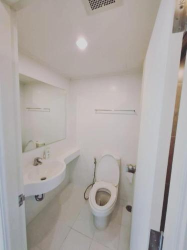a white bathroom with a toilet and a sink at Studio Seaview Jomtien floor12 23sqm in Jomtien Beach