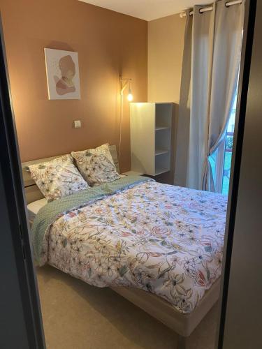 une petite chambre avec un lit et une fenêtre dans l'établissement T2 appartement vue sur port, à Rochefort