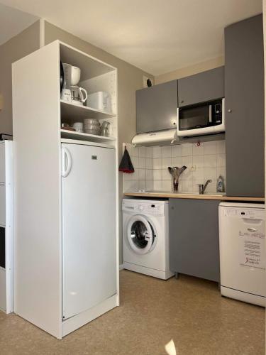 Il comprend une cuisine équipée d'un réfrigérateur blanc et d'un lave-linge. dans l'établissement T2 appartement vue sur port, à Rochefort
