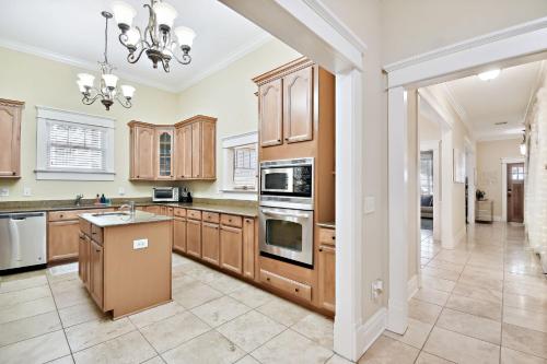 a large kitchen with wooden cabinets and a chandelier at Cozy Hyde Park Home in Tampa
