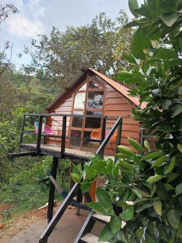 a tree house with a window and two chairs at Cabaña en el Campo in La Vega